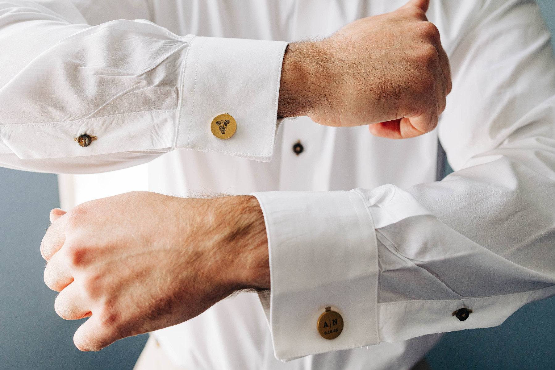 detail wedding photo of groom's custom cufflinks featuring a photo of their dog