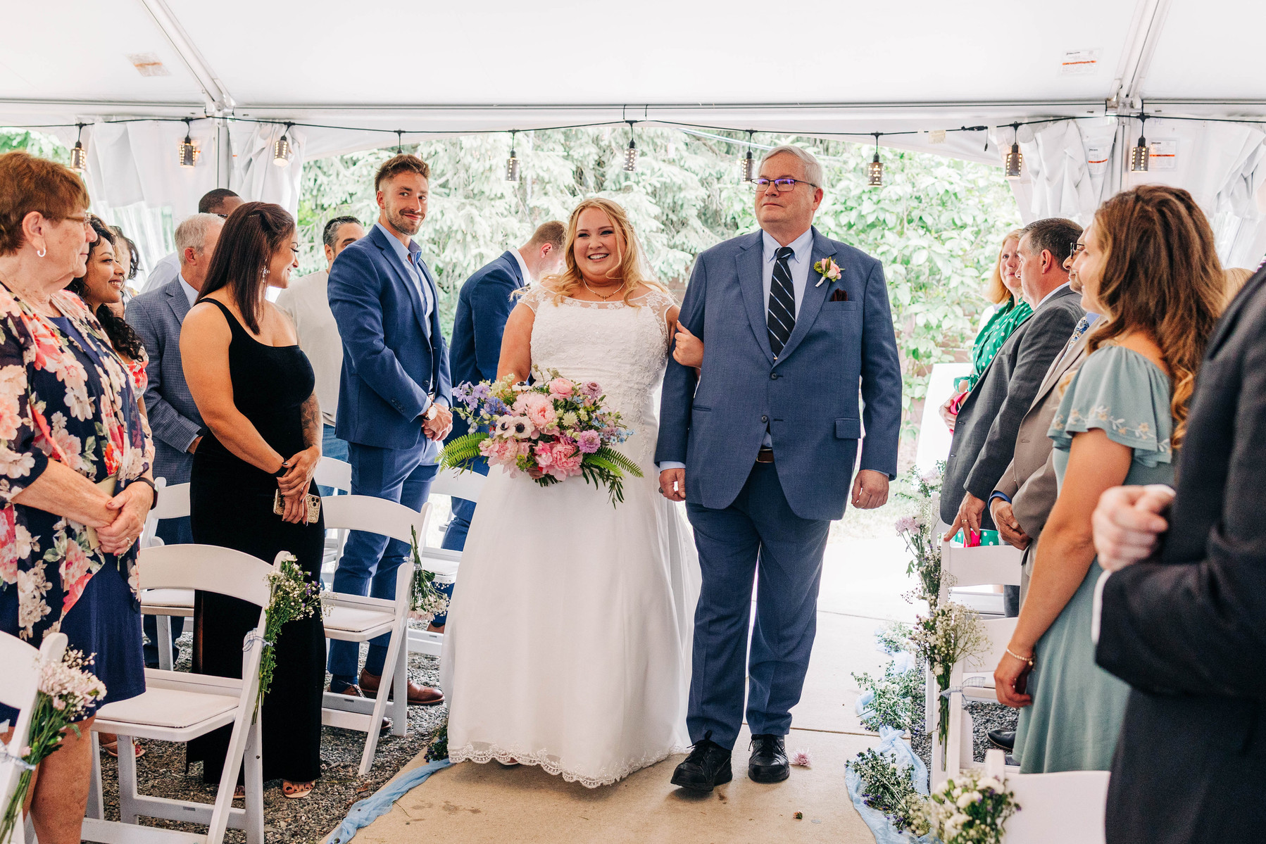 bride walking down the aisle with her dad in outdoor tented wedding ceremony at the farmhouse at people's light theater in malvern pennsylvania
