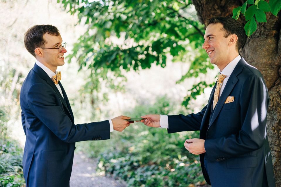 portrait of grooms exchanging letters and gifts at bartram's garden on their wedding day