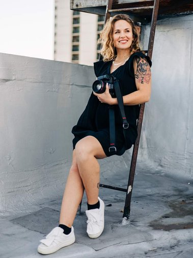 portrait of becca haydu philadelphia wedding photographer on urban rooftop at sunset