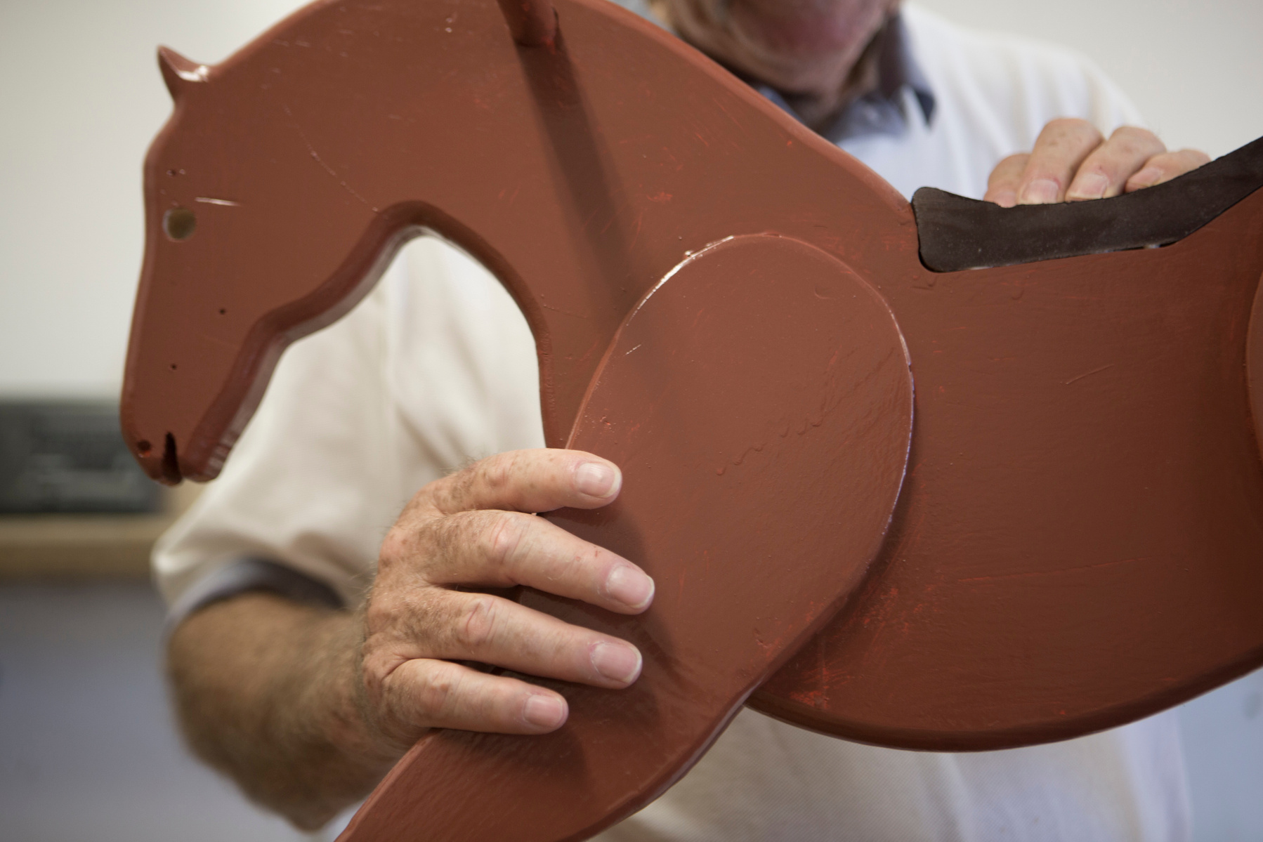 Rick Schemel puts the finishing touches on a rocking horse he made for a student.