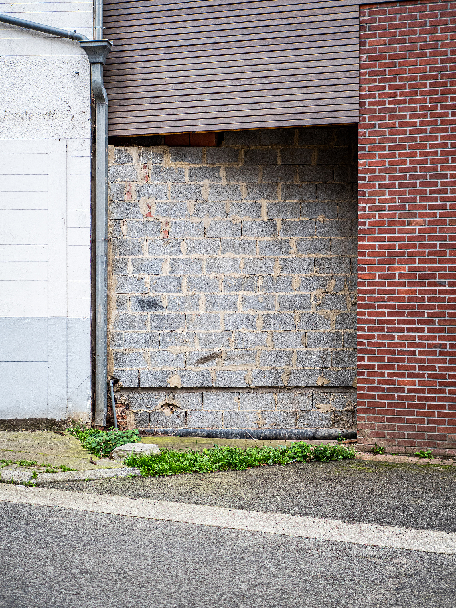 Un mur en parpaing pas fini dans un village. Celles en Belgique.