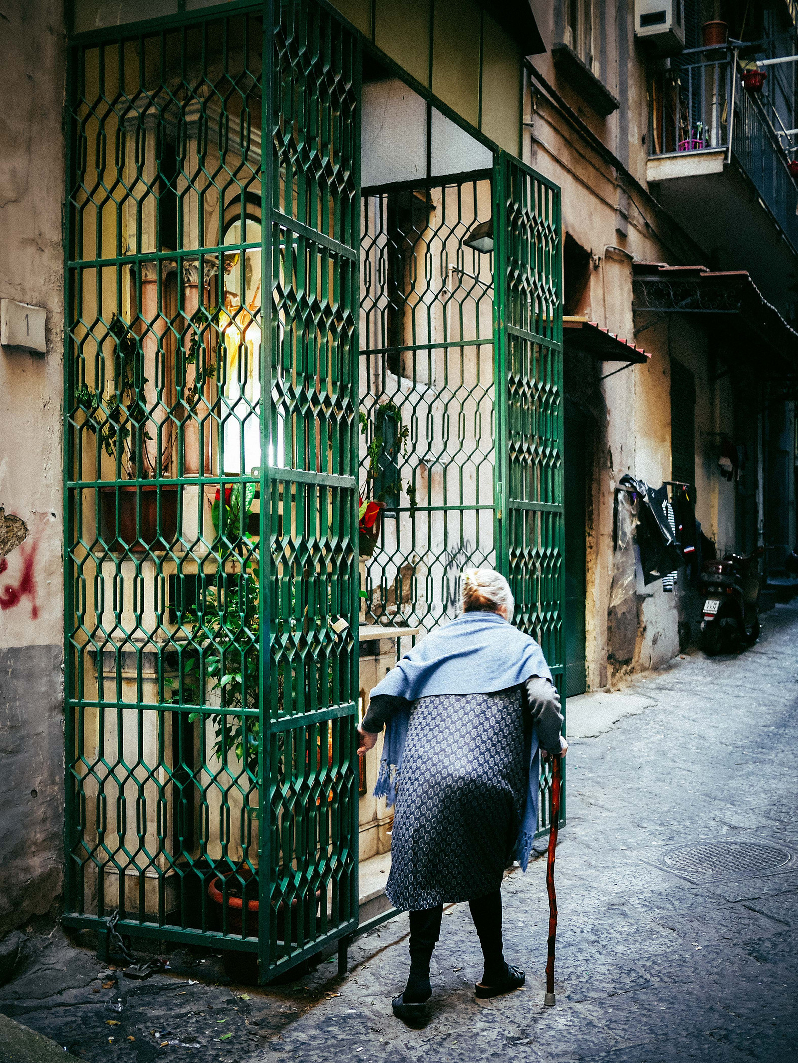 Un vieille dame qui marche avec une canne.