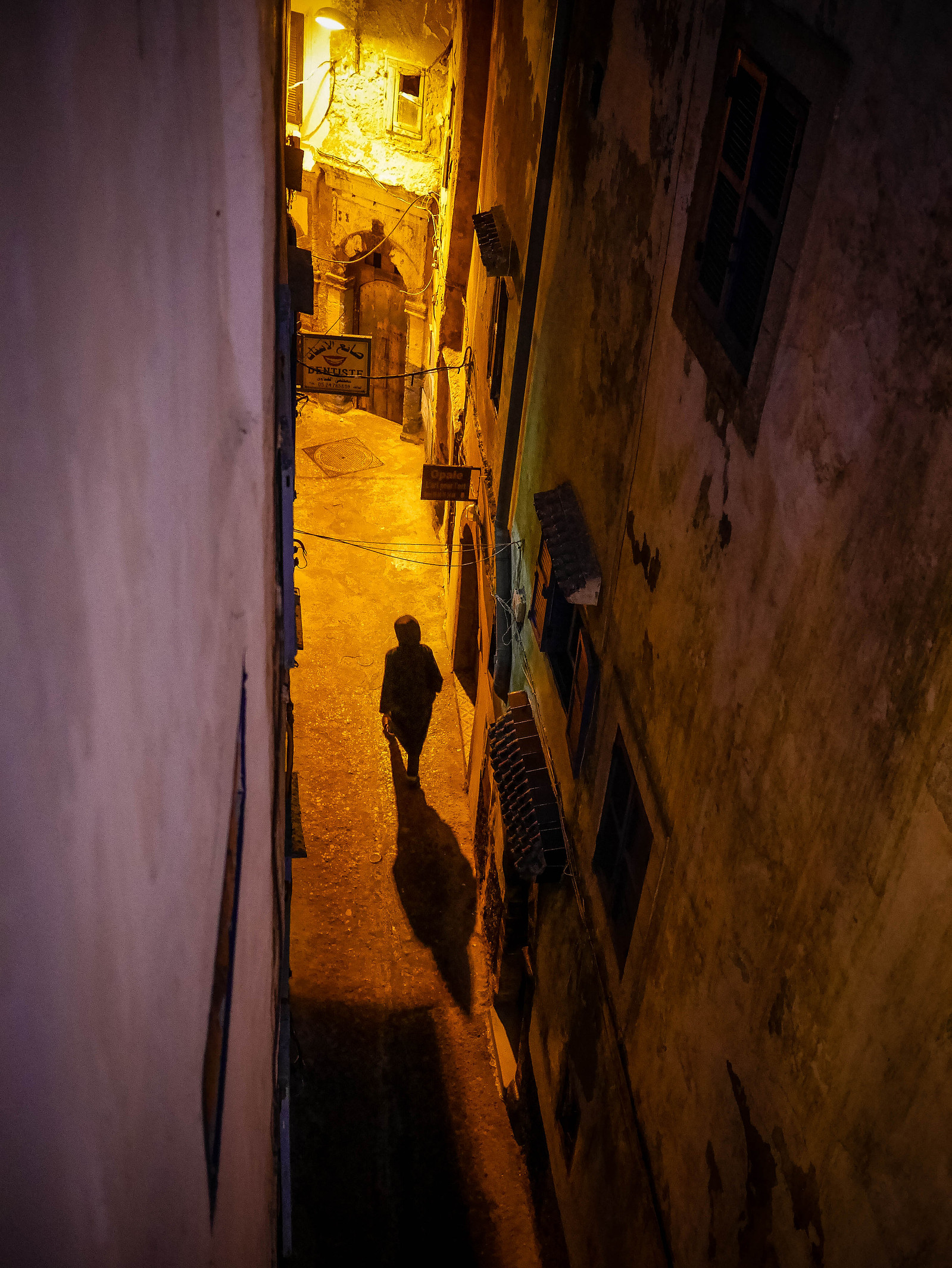 Une silhouette dans une ruelle de nuit.