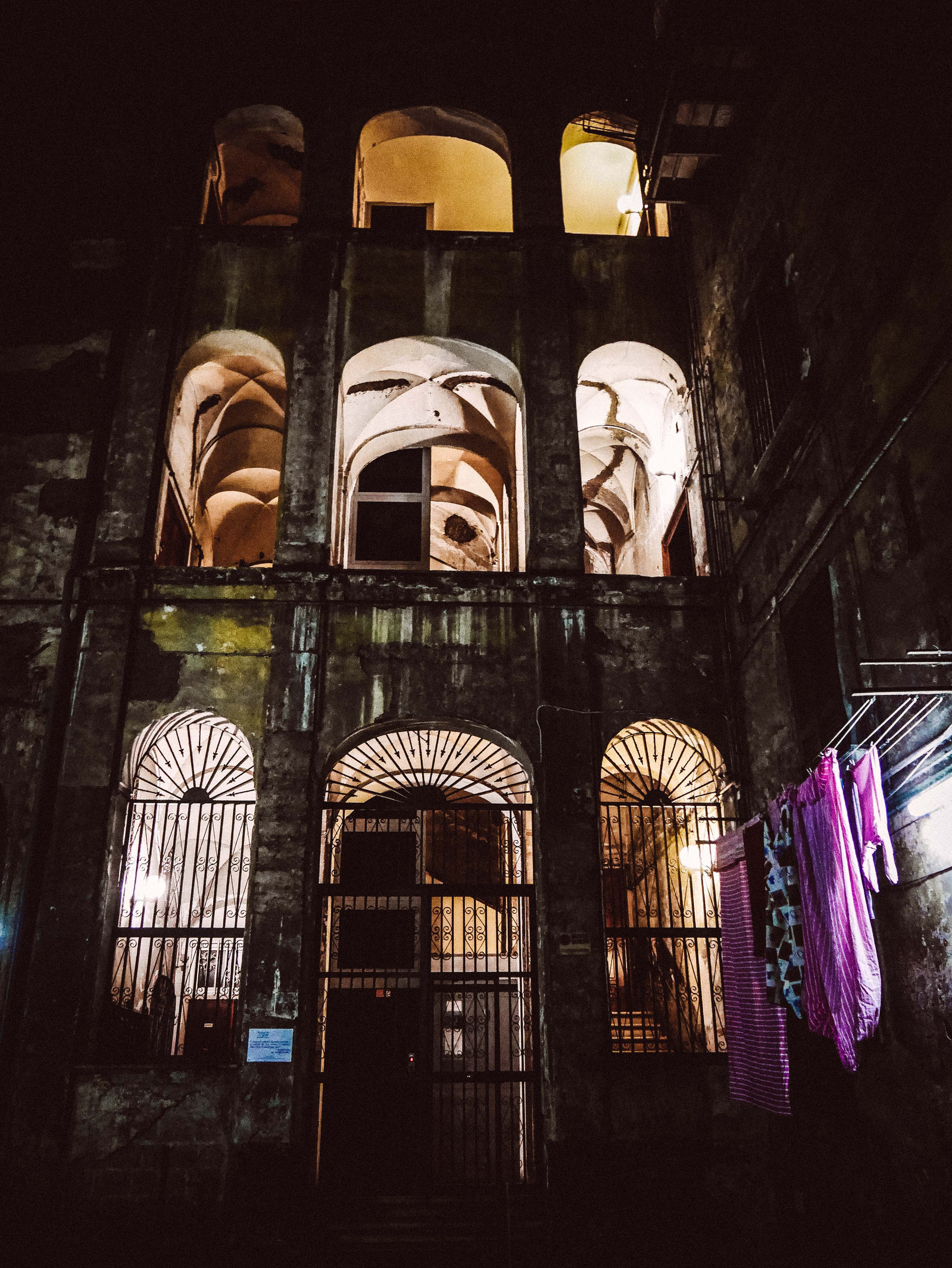 Une cour d'immeuble avec des arcades.