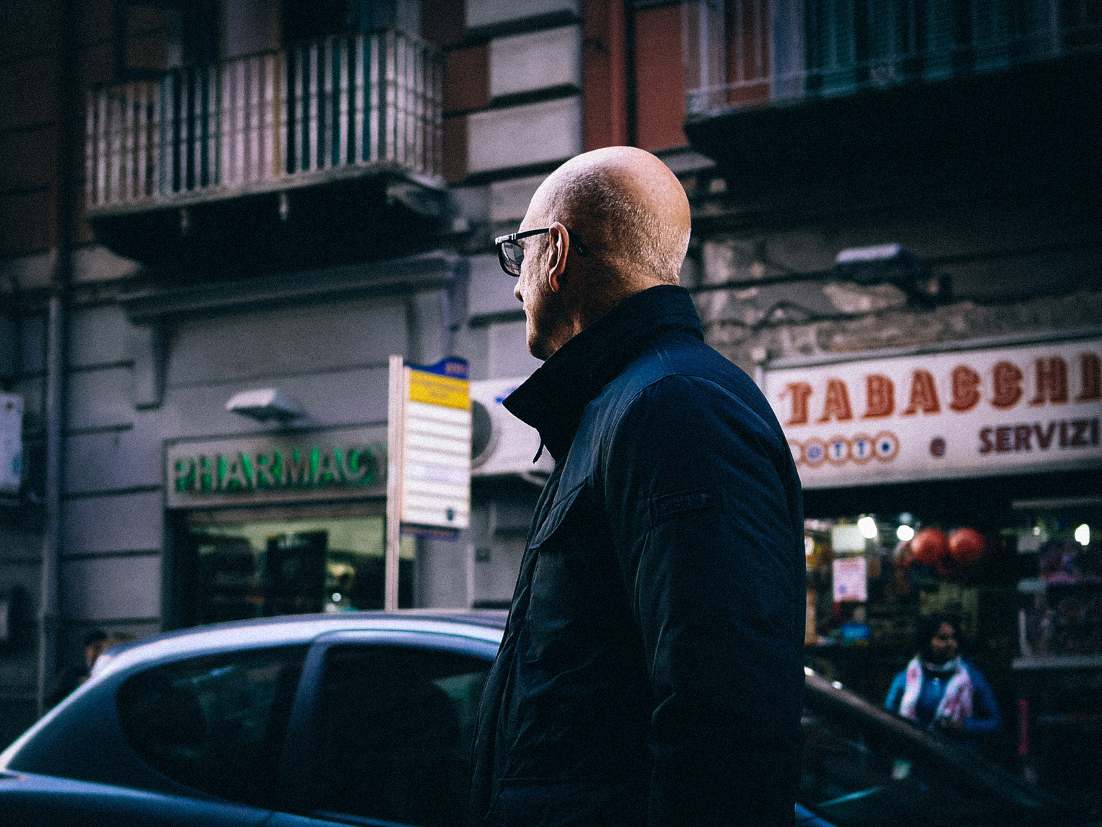 Un homme de dos qui regarde dans la rue.