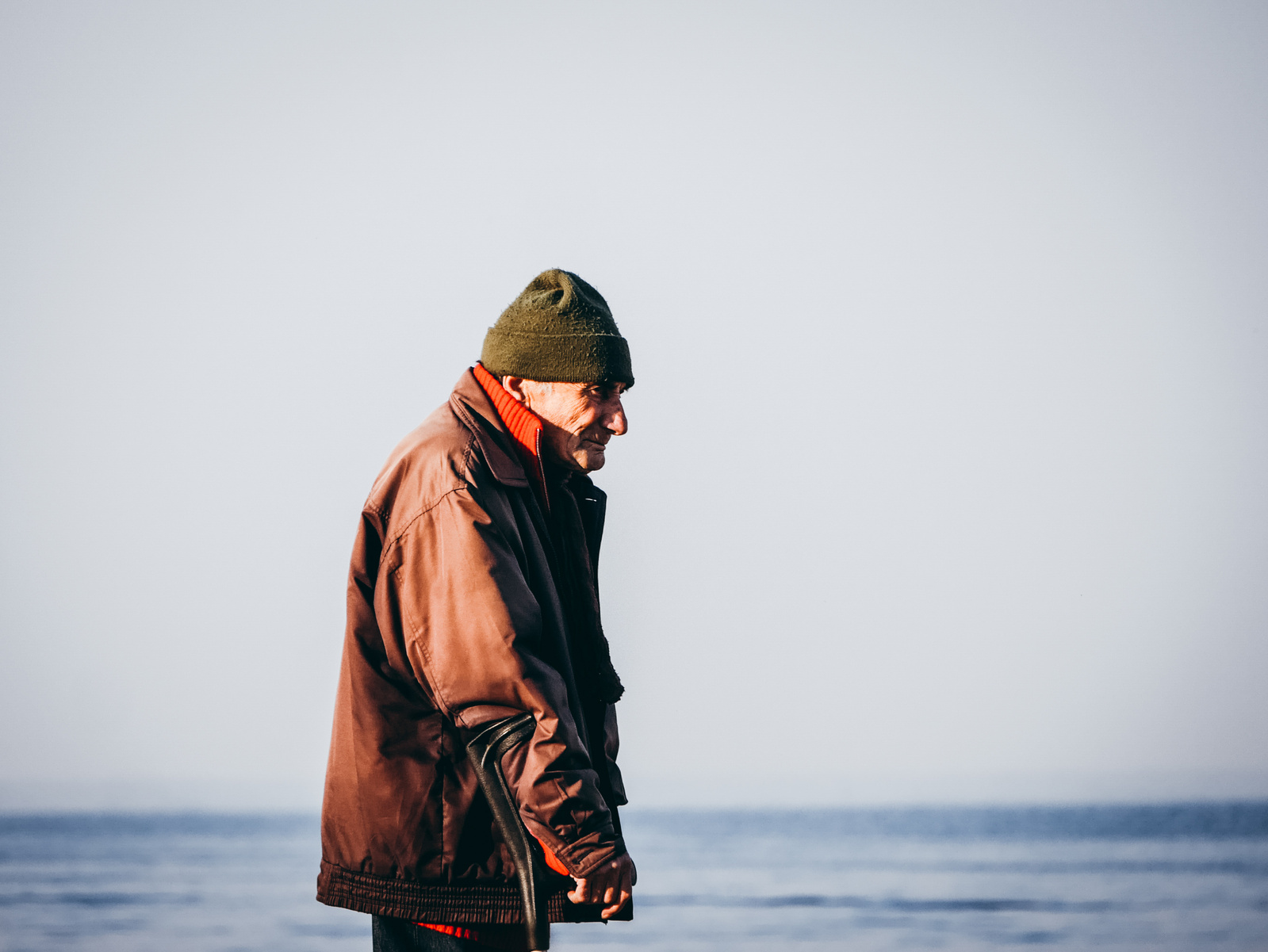 Un homme avec une béquille et la mer.