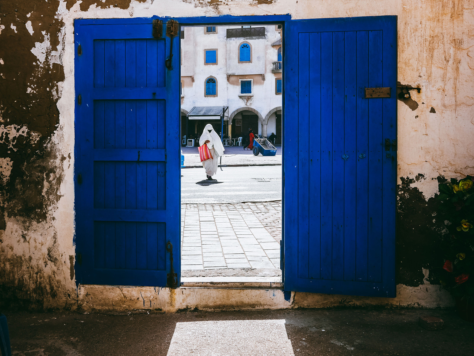 Une femme à travers une porte bleue.