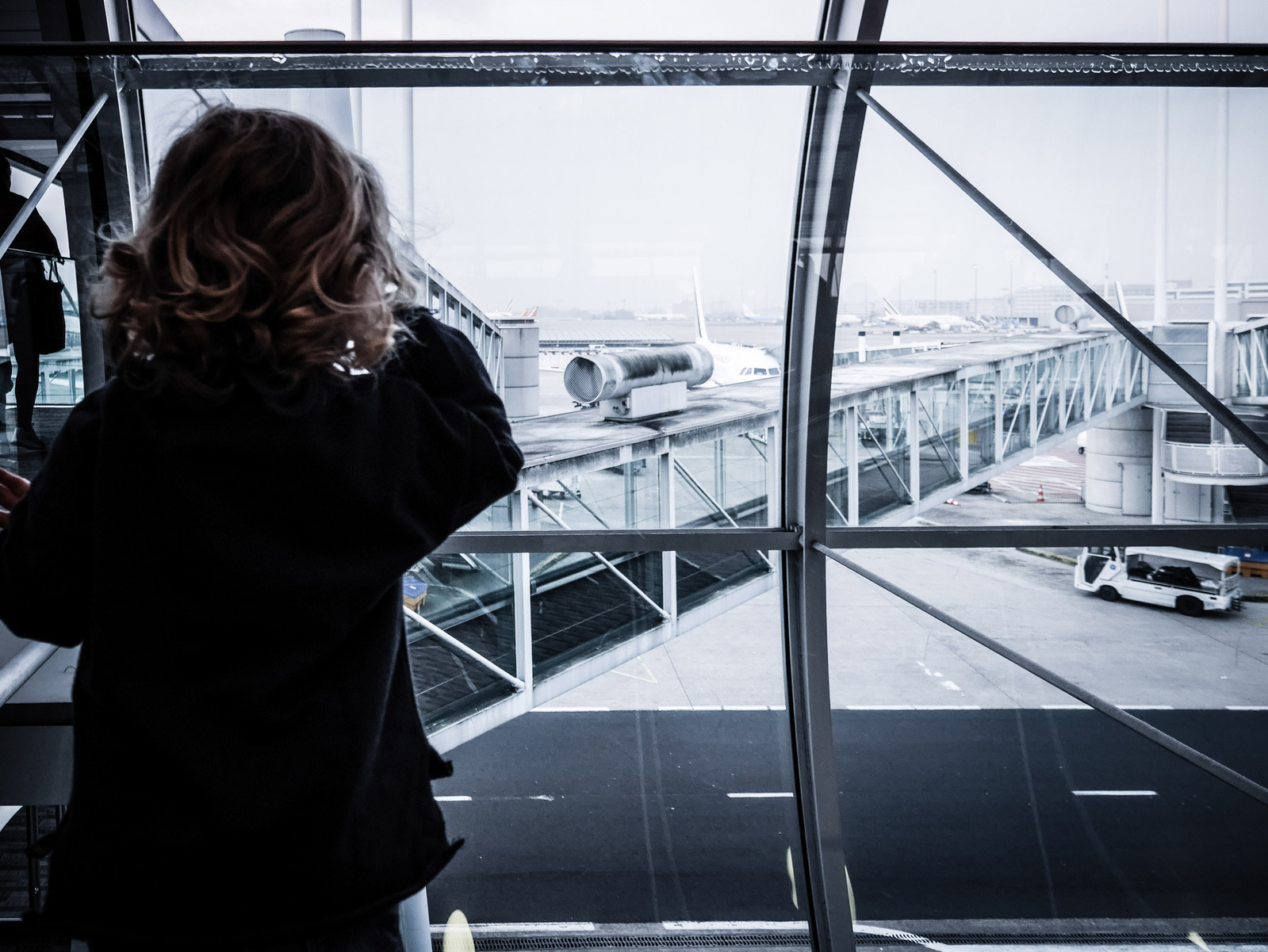 Une petite fille qui regarde un dehors dans un aéroport.