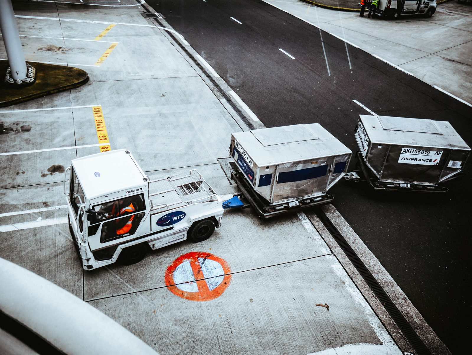 Un véhicule et ses remorques sur un aéroport.