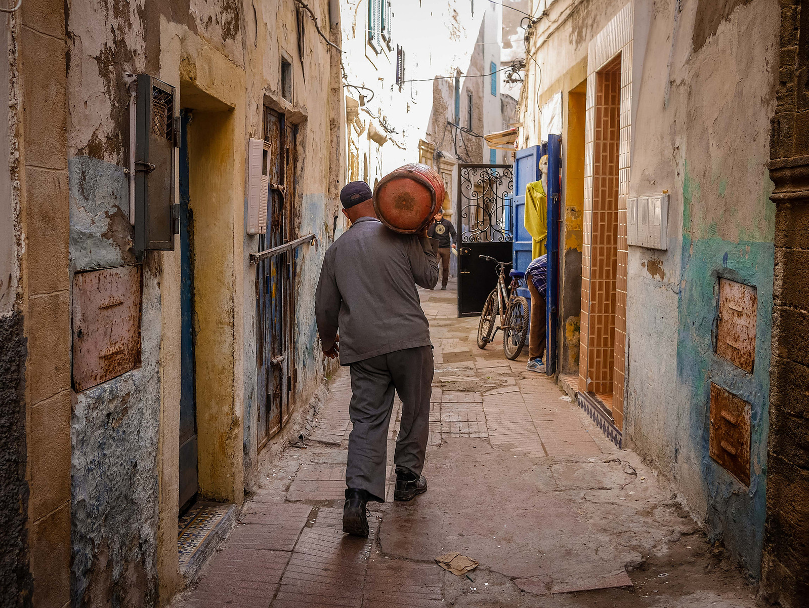 Un homme qui porte une bouteille de gaz.