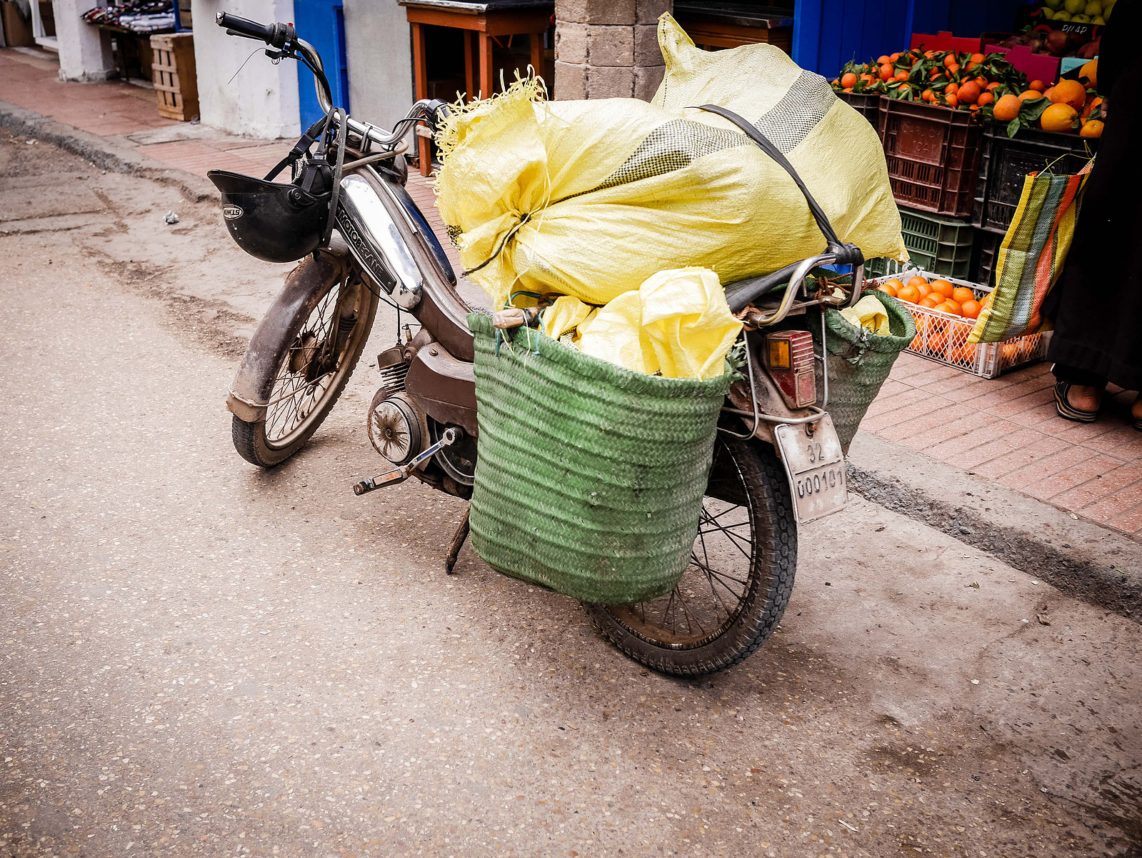 Une mobylette surchargé de sac en plastique.