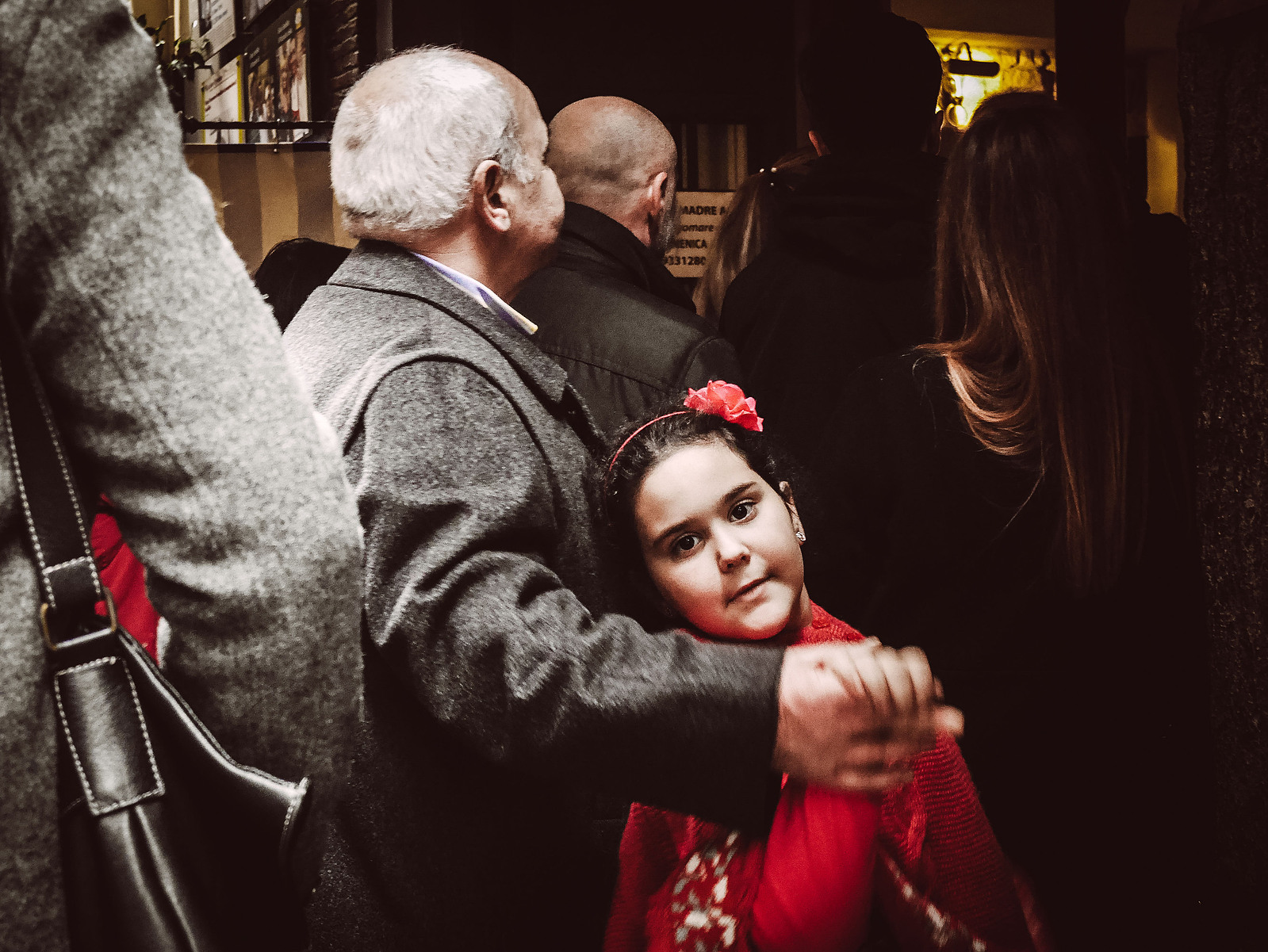 Une petite fille dans les bras de son père regarde l'objectif du photographe.