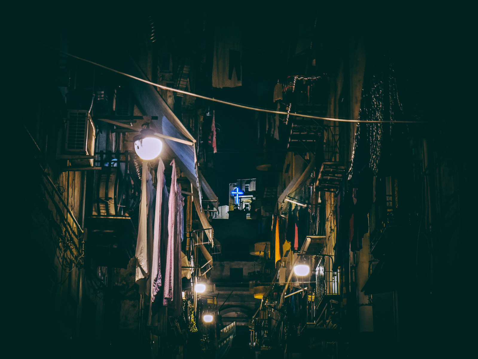 Une croix la nuit dans une ruelle de Naples.