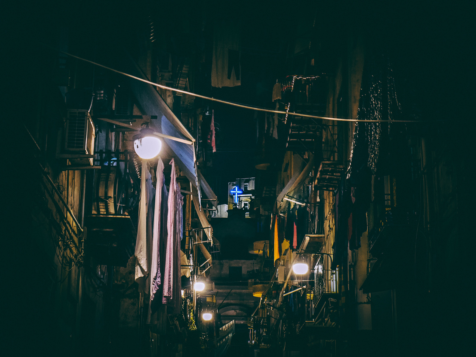Une croix la nuit dans une ruelle de Naples.