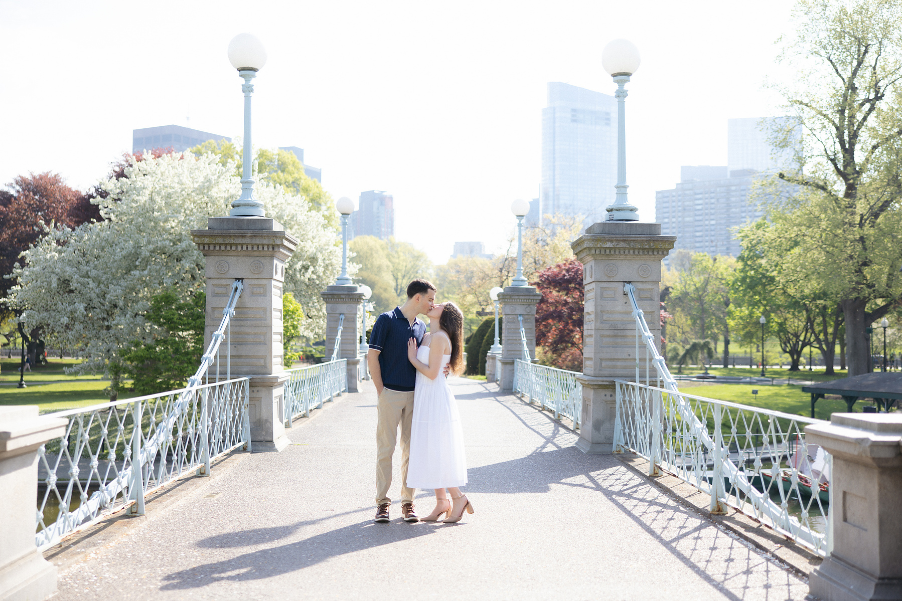 Bride and groom posing on the famous bridge in the boston commons. 