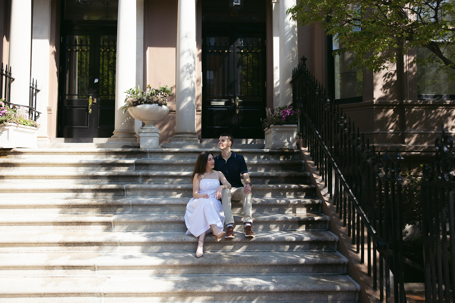 Bride and groom sitting on the stairs leading up to brownstones in boston. 
