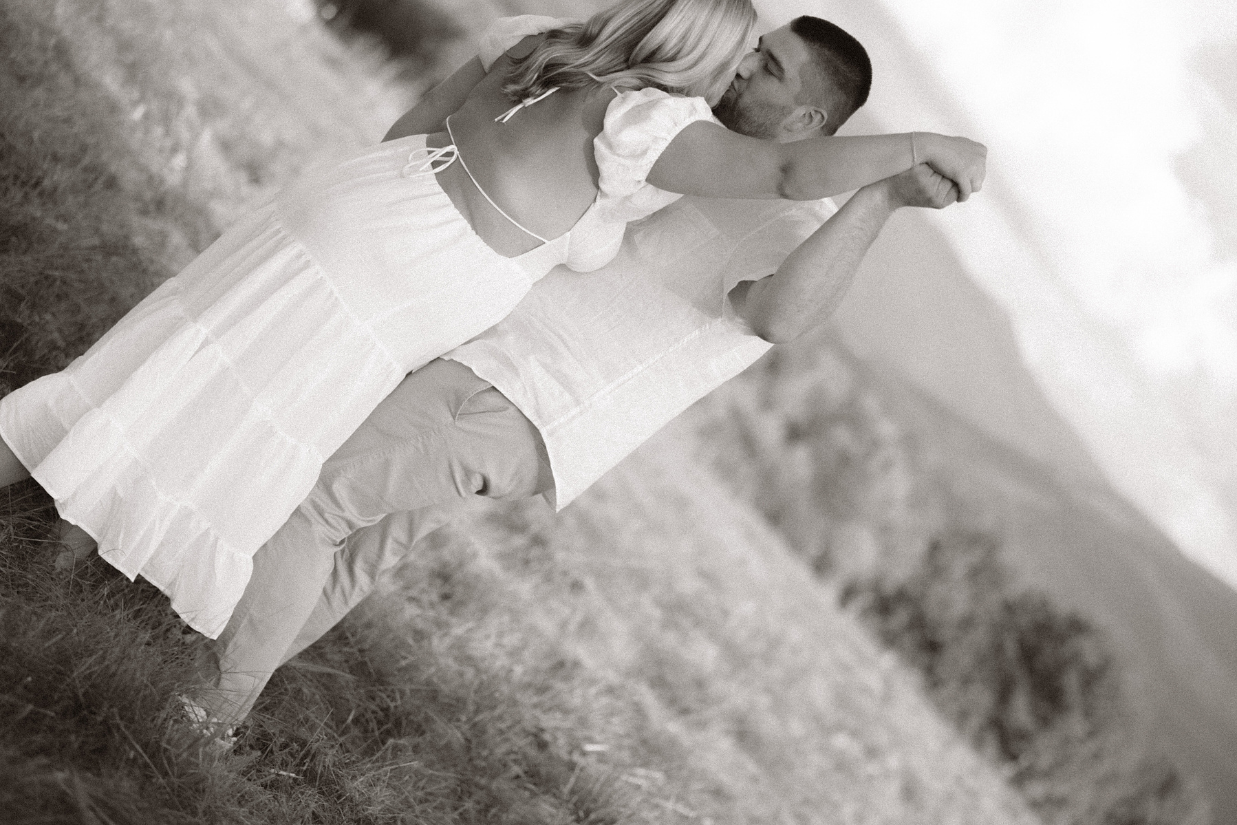 Bride and groom dancing in a field. 
