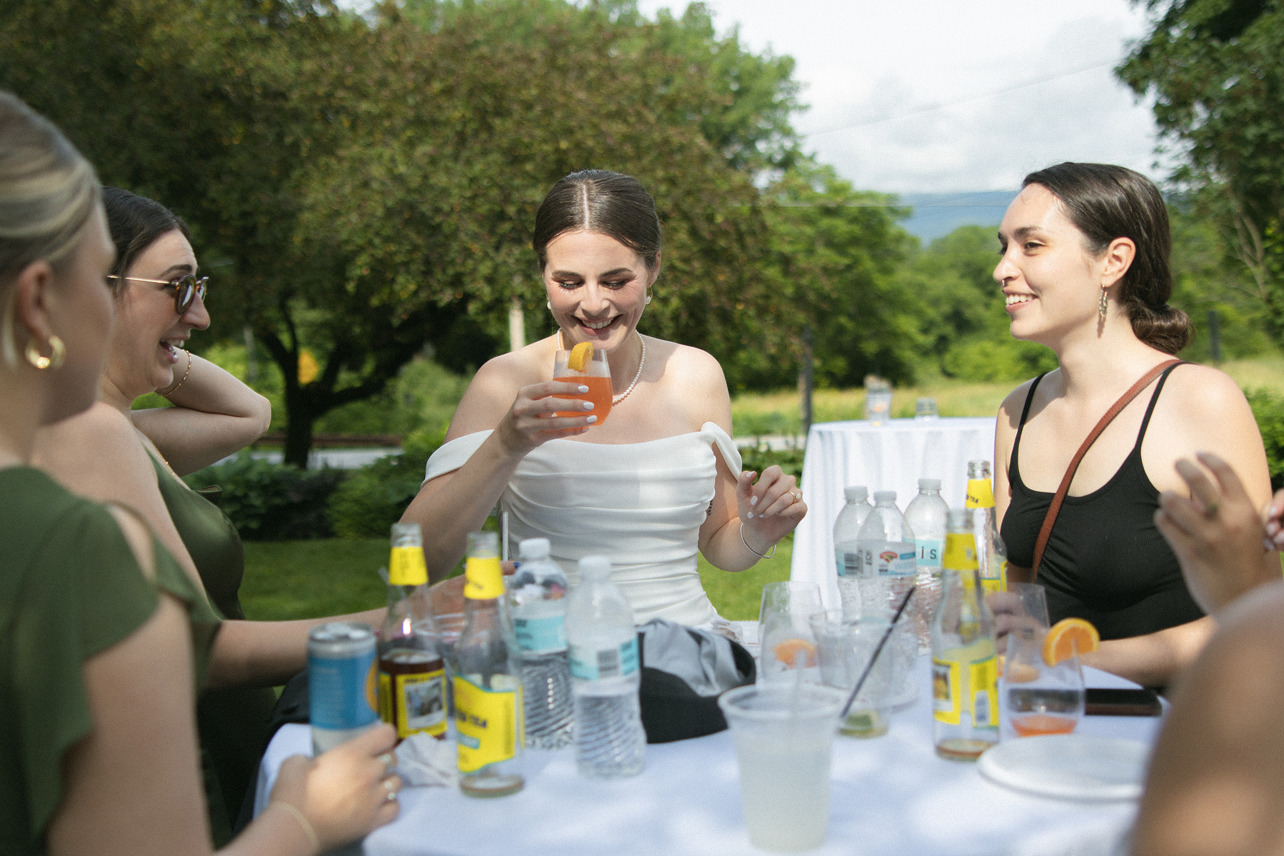 Bride sipping on a cocktail during cocktail. hour. 