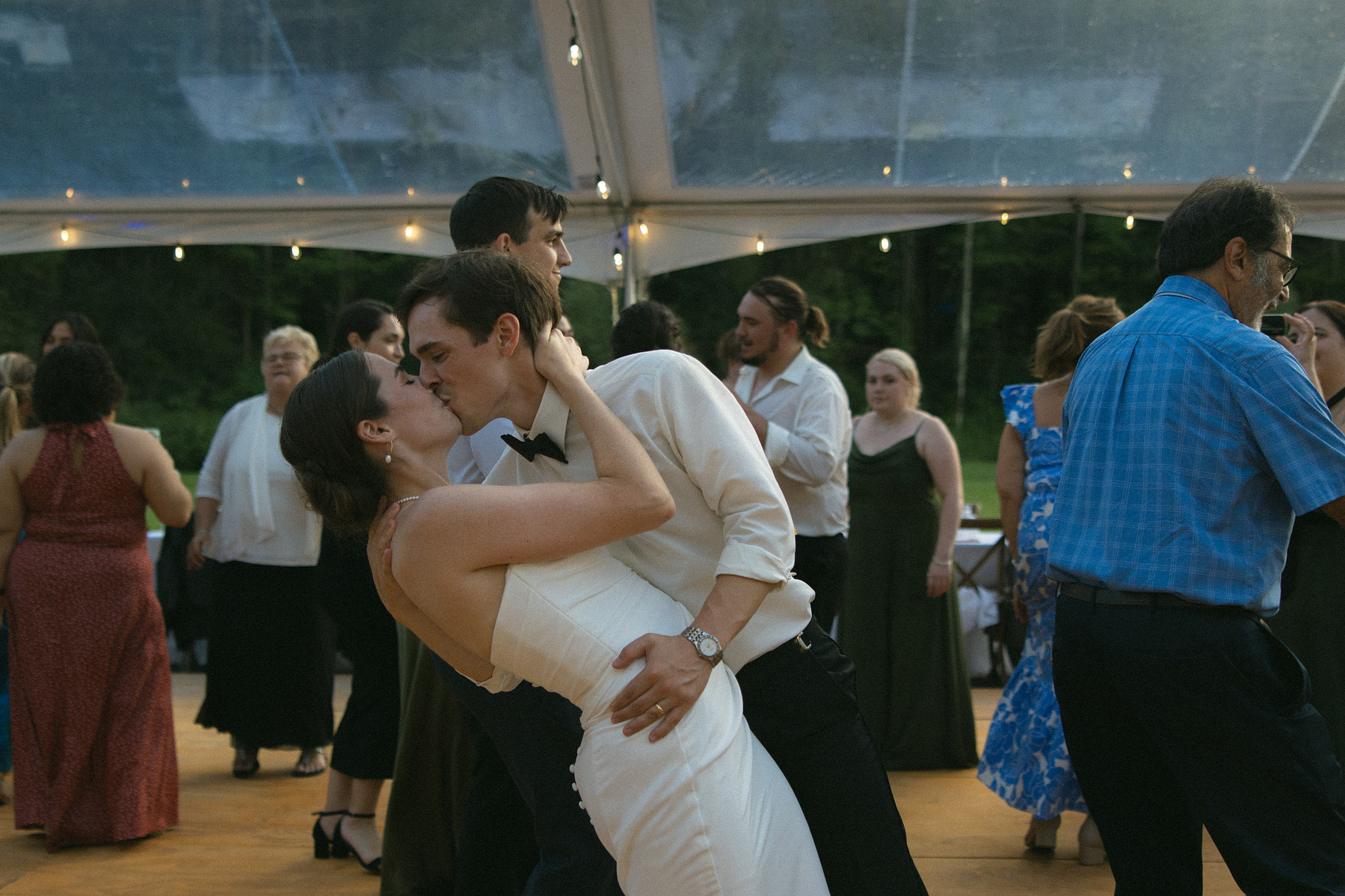 Bride and groom going in for a dip kiss on the dance floor. 