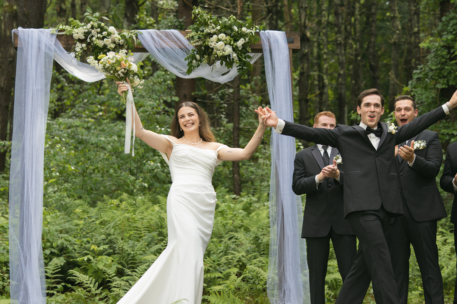 Bride and groom walking of the alter together cheering. 