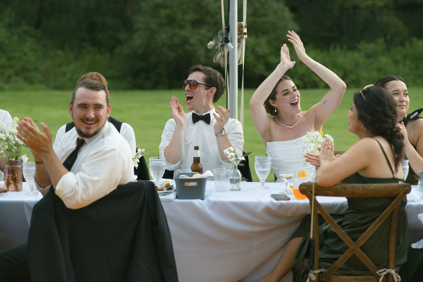 Bride and groom cheering at their table. 