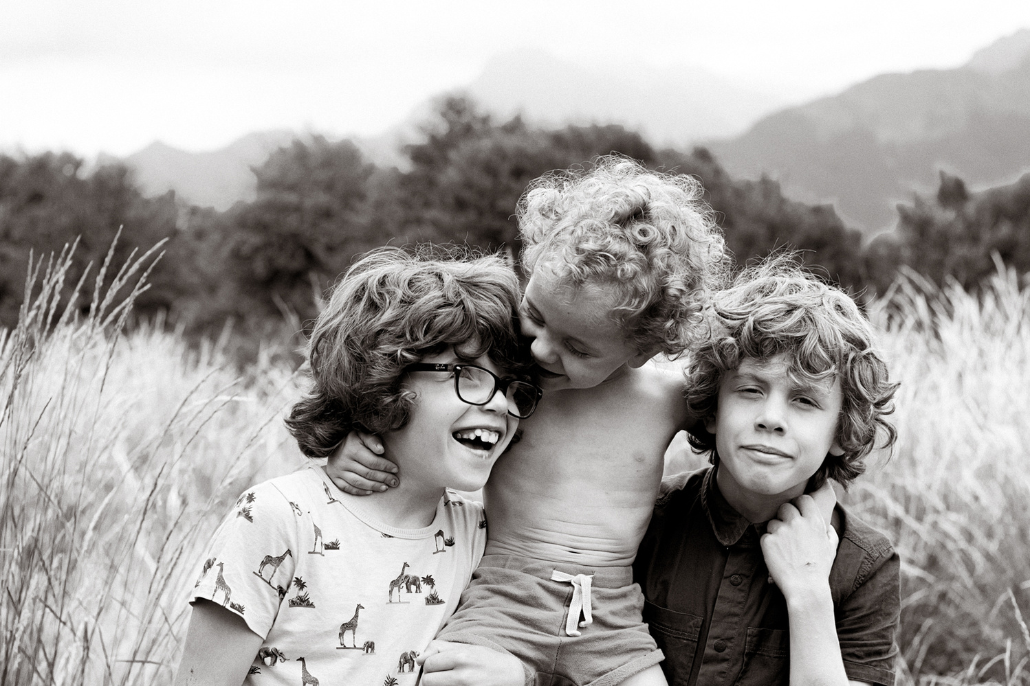 3 broers die genieten van het bij elkaar zijn.
Spelende kinderen die genieten van elkaar in een zwart wit portret