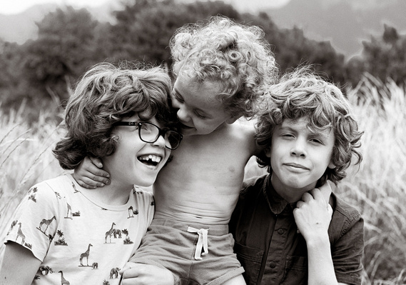 zwart- wit, drie jongens die genieten, 3 jongens die genieten, enjoy, mooie krullen, elkaar vastpakken voor de foto, groepsknuffel, in de bergen, donkere en toch lichte kleuren, belichting 