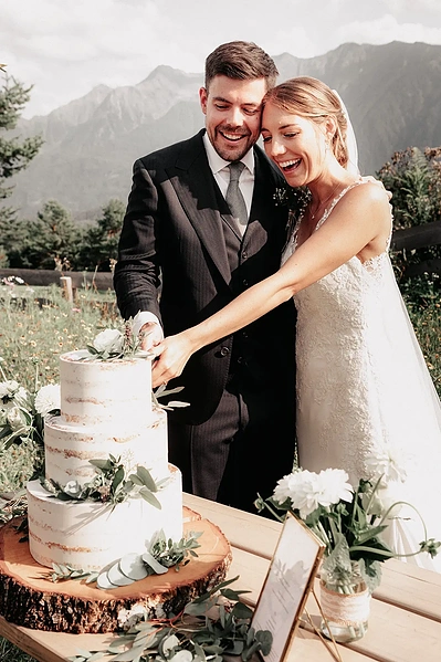Anschnitt der Hochzeitstorte auf der Stoettlalm in Mieming. Hochzeitsfotografie in Tirol