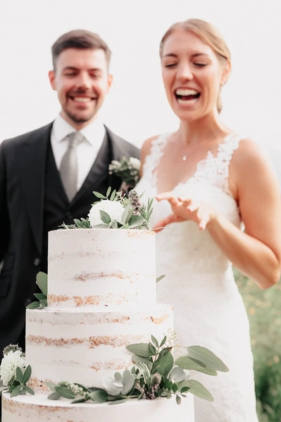 Anschnitt der Hochzeitstorte auf der Stoettlalm in Mieming. Hochzeitsfotografie in Tirol