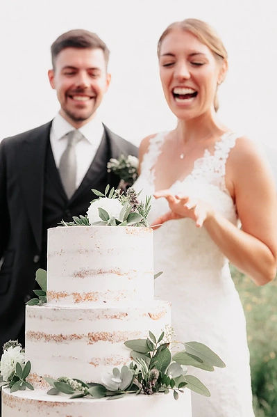 Anschnitt der Hochzeitstorte auf der Stoettlalm in Mieming. Hochzeitsfotografie in Tirol
