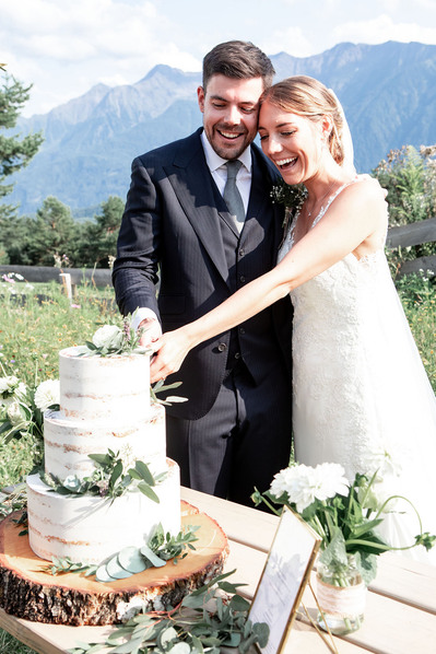 Brautpaar schneidet die Hochzeitstorte an auf der Stoettlalm in Mieming in Tirol.
Hochzeitsfotografie