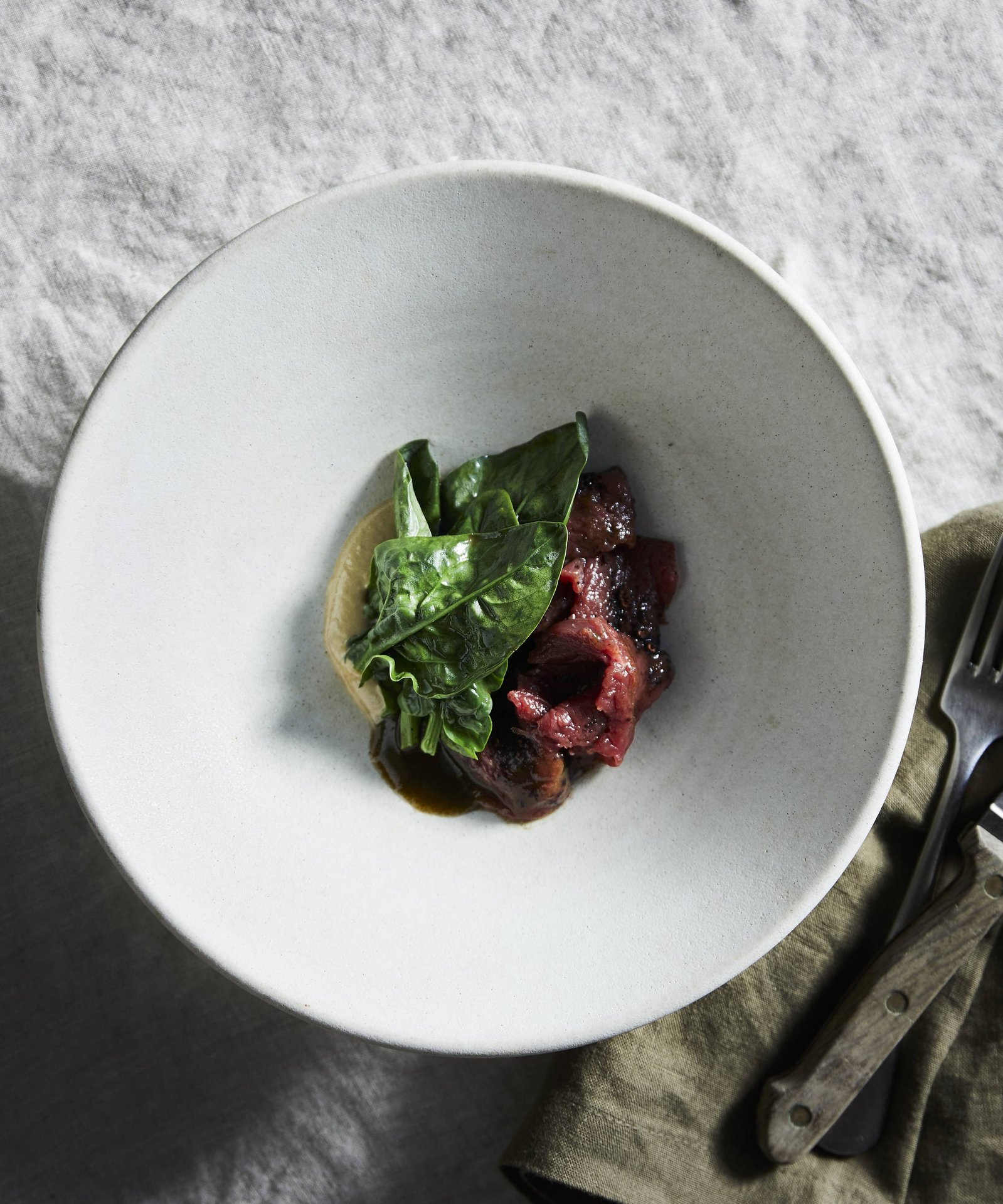Wallaby dish with fresh vegetable leaf in Tasmania taken by Sydney food photographers Nic Gossage