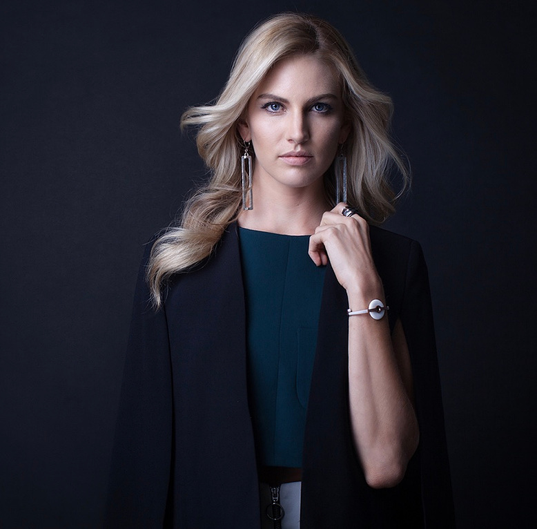 blond model with a soft curl hairstyle wearing a black dress
