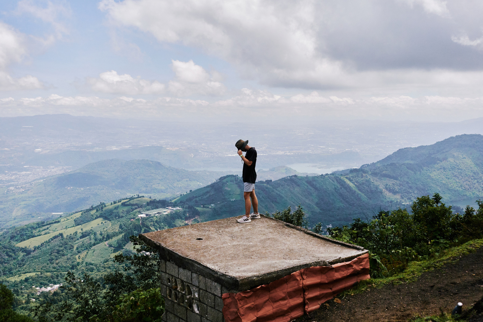 Man standing on cliff looking out into beautiful landscape