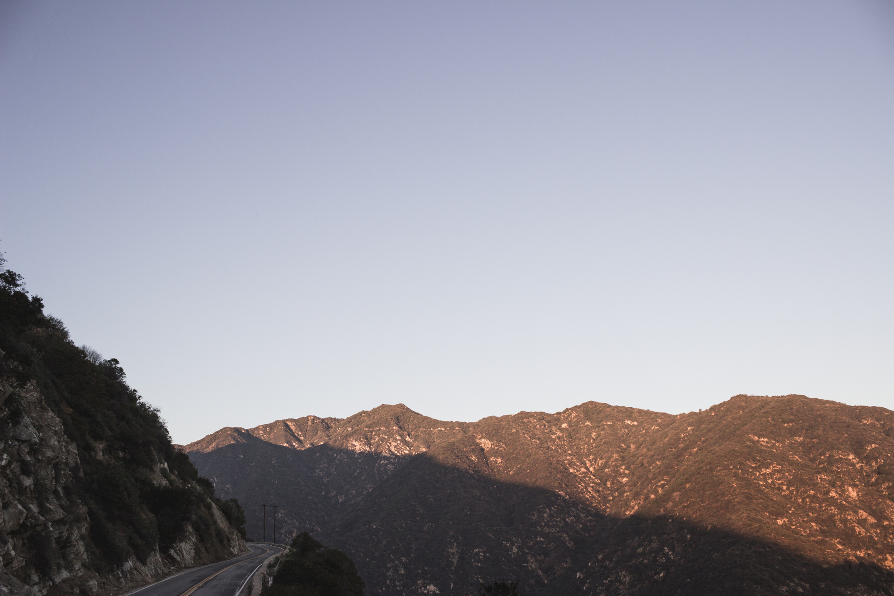 Highway view of mountain cap and blue sky behind