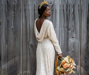 Bride wears vintage inspired sequin bridal gown with cowl back, long sleeves and puddle train