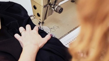 Closeup of bespoke wedding dress maker at her sewing machine