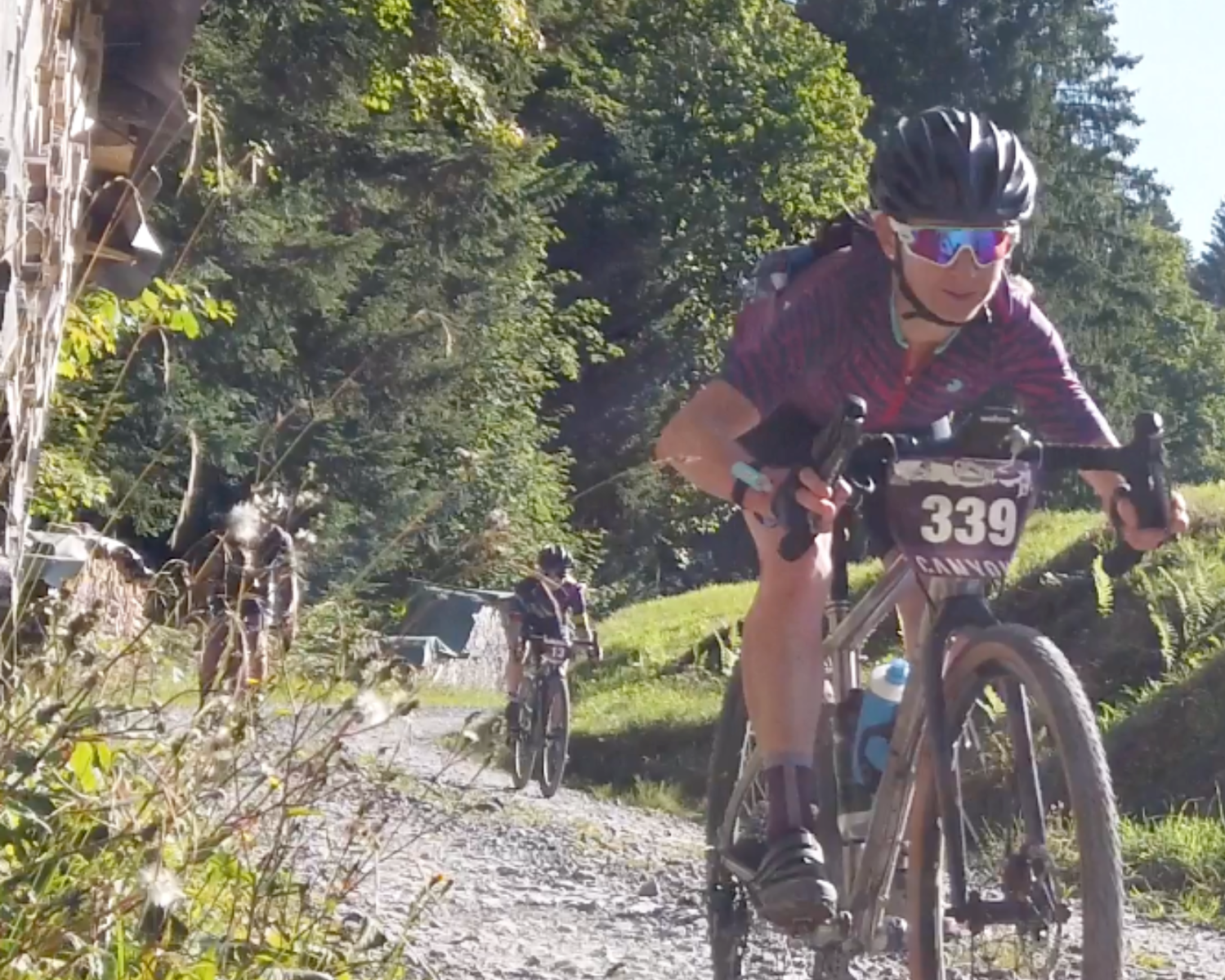 A woman riding a gravel bike downhill.