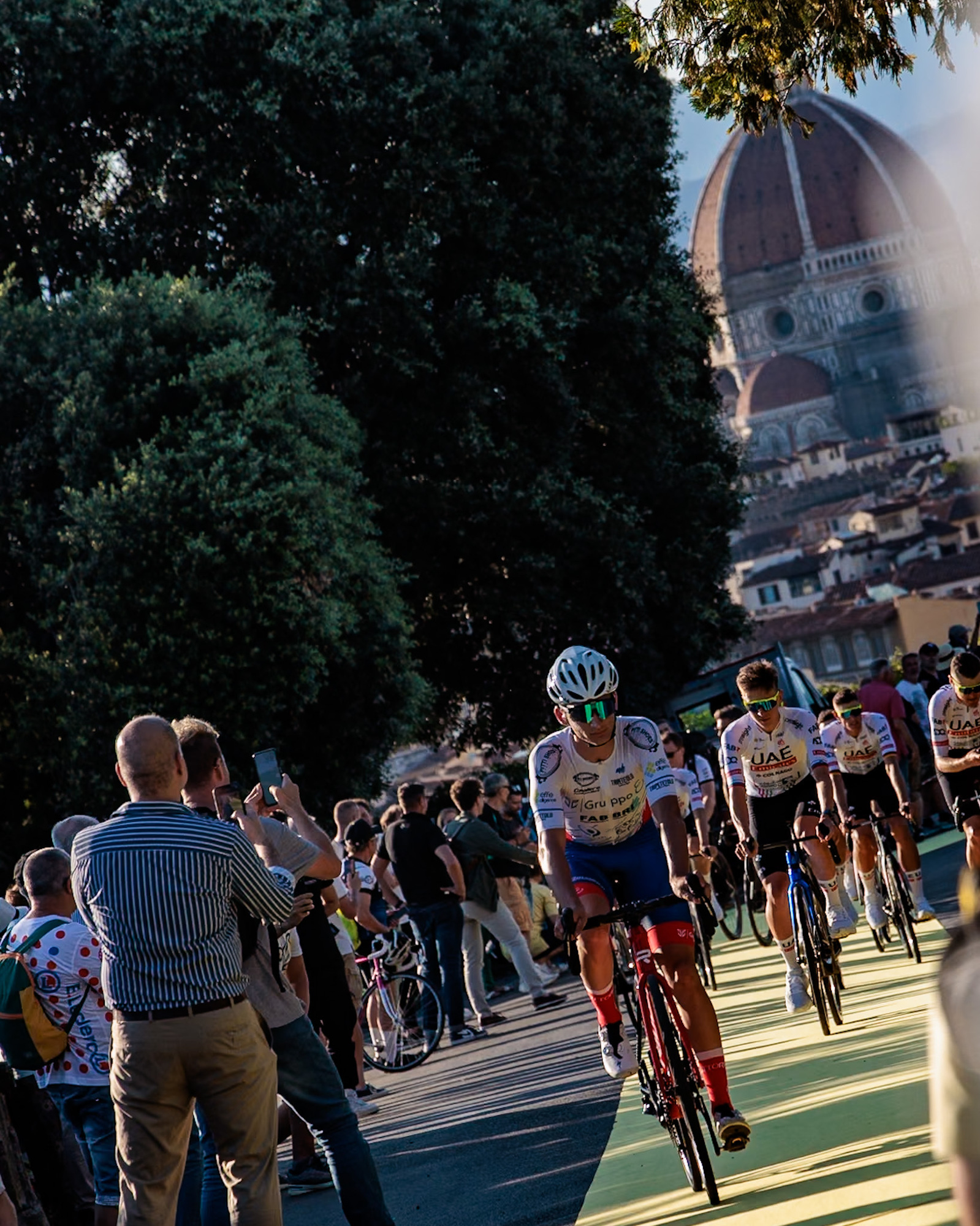 Tadej Pogačar cycling toward the beginning of the Tour de France, Florence. Brunelleschi's Dome in the distance.
