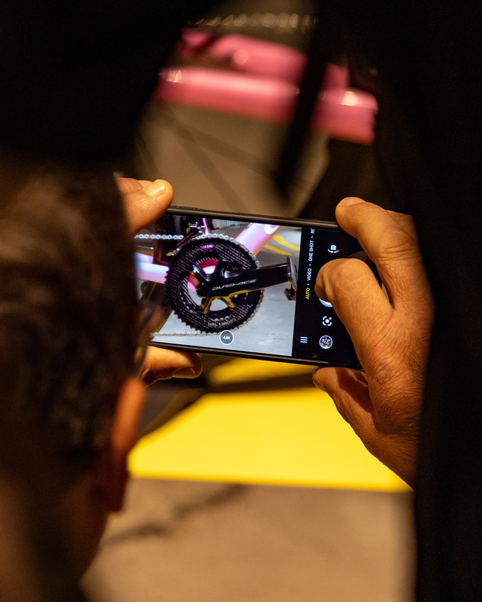 A man takes a photograph of Shimano Dura Ace gears