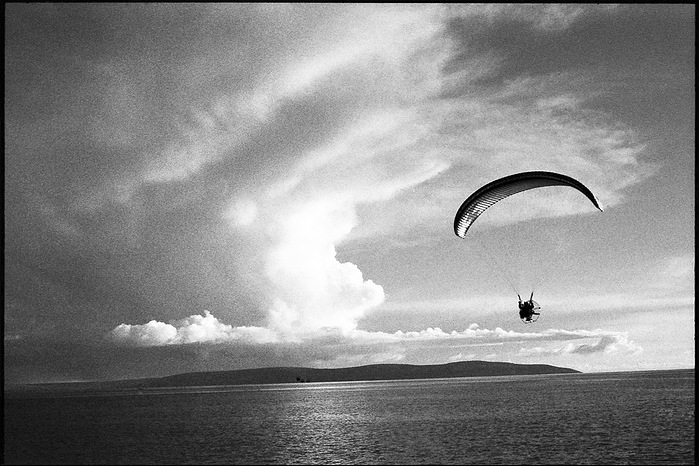 Parachuting in the sky over the sea.