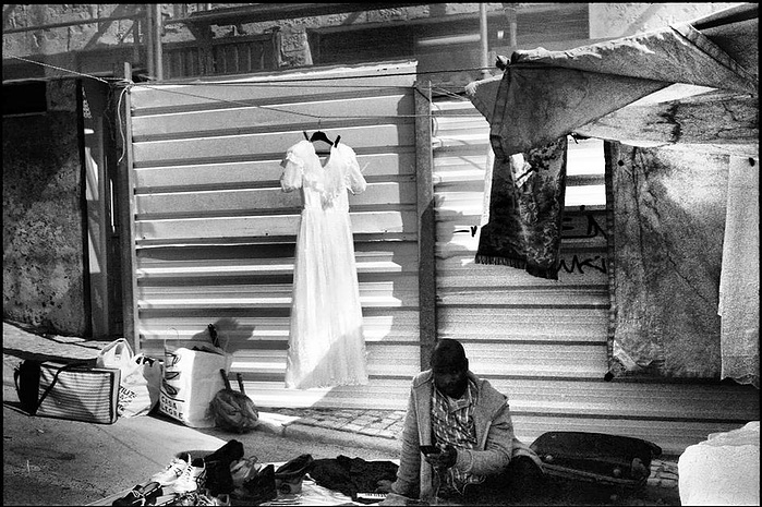A black seller selling wedding dress in a market Feira da Ladra in Lisbon