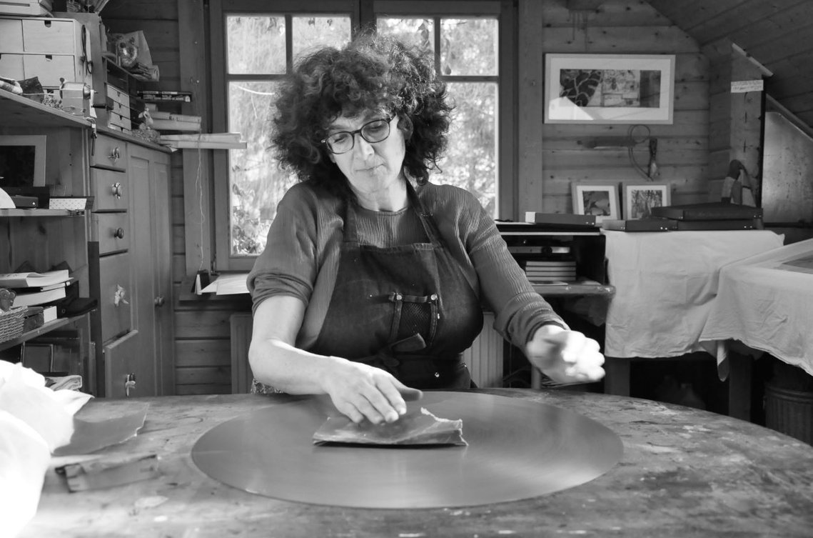 Danielle Grosbusch en train de traîter une plaque en cuivre dans son propre atelier.
