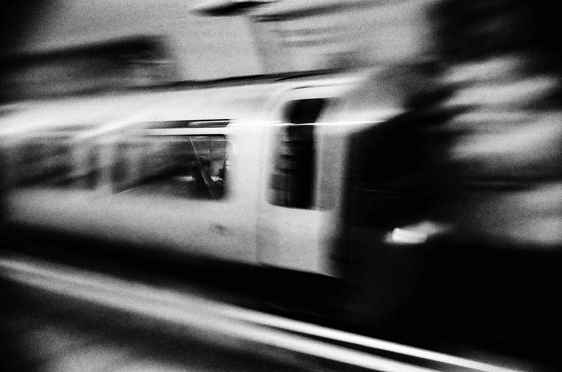 Black and white image of a train pulling up to the platform at Tottenham Court Road Station, Northern Line in February 2022.