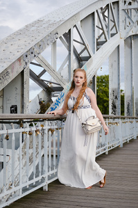Jeune femme en robe blanche sur un pont métallique