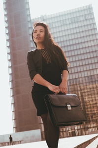 Jeune femme dynamique portant une mallette de travail