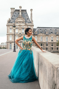 Jeune femme en robe bleu turquoise sur le pont du Carrousel à Paris