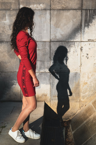 Une jeune femme mince et son ombre sur le mur