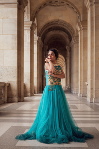 Jeune princesse vêtue d&amp;#x27;une robe bleue sous les arches du Louvre à Paris